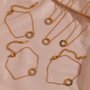 Close-up of 18K gold twisted circle pendant necklaces and bracelets with crystal inlay