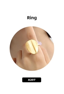 Detail of a matte gold irregular round ring featuring a textured brushed finish surface