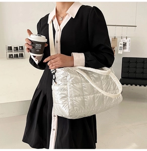 Detailed view of white quilted padded handbag with diamond stitching and shoulder strap