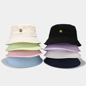 Multiple colors of cotton bucket hats featuring detailed yellow smiley face embroidery