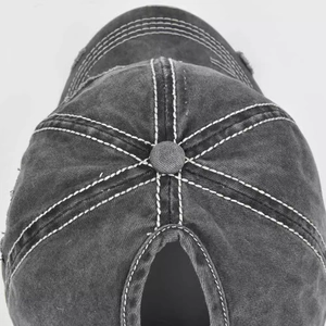 Detail of a washed dark grey ponytail baseball cap with distressed holes and contrast stitching