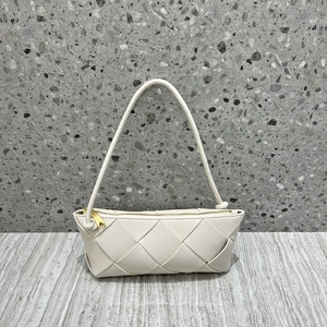 Detailed view of white woven leather handbag texture with premium gold zipper and strap