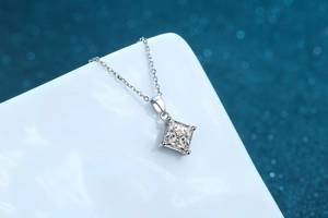 Macro shot of princess cut square moissanite pendant with four-claw setting on silver chain