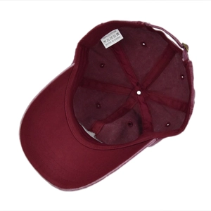 Detailed inner view of burgundy cotton baseball cap showing wash label and metal buckle