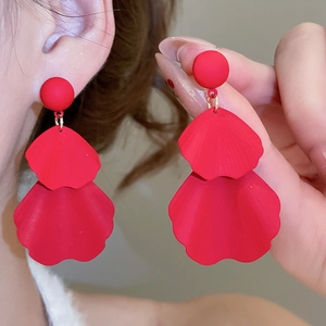 Detailed macro view of matte red double-layered petal earrings with gold rings and silver pins