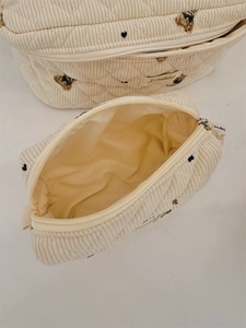 Detail of cream corduroy bear embroidery storage pouches with quilted pattern and zippers