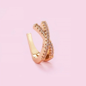 Detail of rose gold X-shaped ear cuff featuring sparkling crystal inlay and elegant design