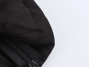 Détail de la texture du tissu noir côtelé et de la fermeture éclair de ce crop top chic