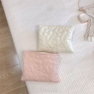 Close-up of quilted floral embroidery on soft padded down cosmetic hand bags