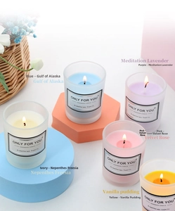 Frosted glass jar scented candles with colorful soy wax on geometric pedestals