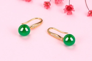 Macro shot of silver chalcedony earrings with green agate beads and sparkling zircon hooks