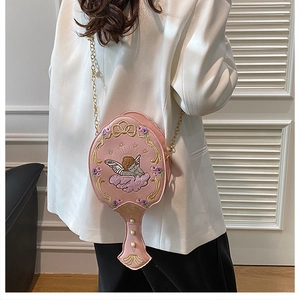 Detail of pink hand-mirror-shaped bag with angel embroidery and pearl accents