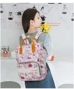 Floral print diaper backpack with yellow handles and spacious front pocket for moms