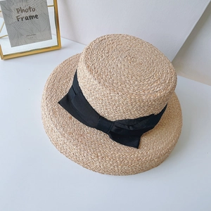 Natural raffia wide brim sun hat with black ribbon bow in a classic retro style
