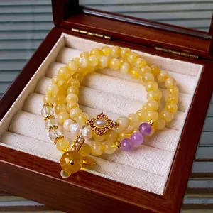 Elegant multi-strand bracelet featuring yellow crystals, pearls, and gold floral accents
