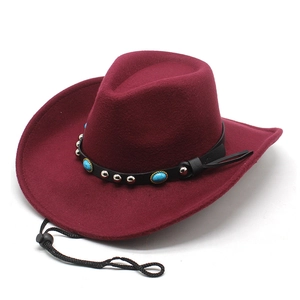 Détail du chapeau en laine bordeaux avec bande en cuir et ornements turquoise