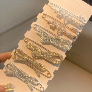 Detailed view of pearl and rhinestone safety pins for waist tightening and decoration