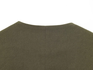 Macro shot of olive green twill fabric showing high-density texture and neat sewing detail