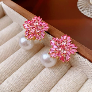 Macro shot of pink floral crystal earrings with elegant large round white pearls
