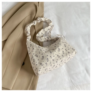 Close-up of cream floral tote bag with purple prints and ruched elastic shoulder strap