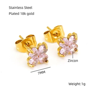 Détail de boucles d'oreilles trèfle en acier plaqué or 18 carats avec zircons roses