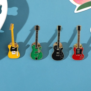 Close-up of four colorful enamel guitar brooches with detailed electric guitar craftsmanship