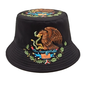 Detailed embroidery of Mexican national emblem on a black bucket sun hat surface