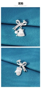 Detailed view of silver Christmas earrings with rhinestone bow, hat and snowflake glove charms