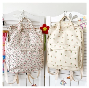 Detail of floral printed canvas backpacks with adjustable straps and front zip pockets