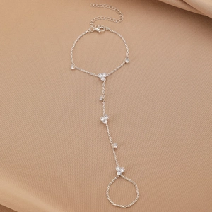 Detail view of silver finger bracelet chain with clear crystals on fabric background