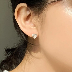Minimalist 925 sterling silver heart stud earring with zircon stone worn by a model