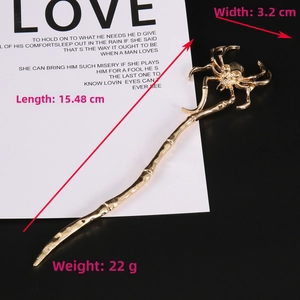 Detail view of a gothic gold spider hair pin with skull head design and measurements