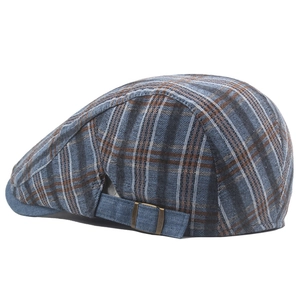 Detail view of colorful plaid flat cap showing bronze adjustable buckle and fabric texture