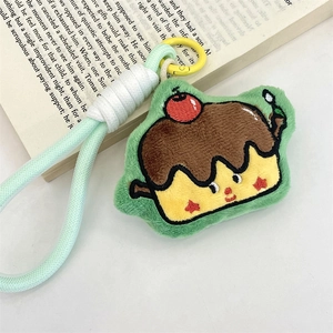 Macro detail of plush cartoon charm with embroidery on open book background