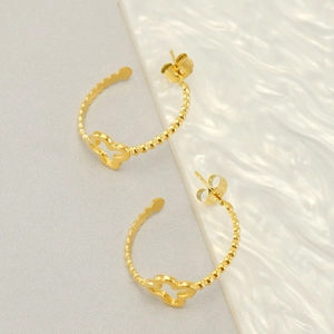 Gold stainless steel beaded hoop earrings with hollow clover charms on a modern textured base