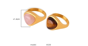 Detail view of triangular rose quartz and tiger eye stones in gold stainless steel rings