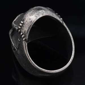 Retro silver skull mask ring with gothic textured finish on black mirror background