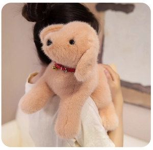 Gros plan d'une peluche de chien Golden Retriever avec collier rouge et clochette