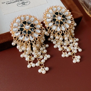 Macro view of vintage gold earrings with heart enamel, rhinestones and pearl tassels
