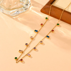 Elegant gold titanium steel jewelry set with colorful zircon gemstones on wood tray