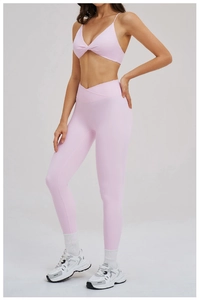 Dettaglio del set yoga rosa con reggiseno a V incrociato e leggings a vita alta
