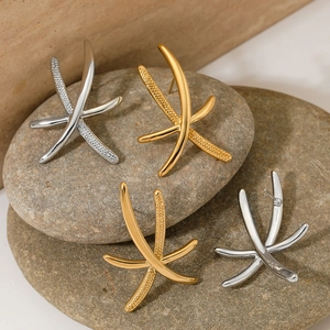 Detailed view of starfish earrings featuring polished gold and silver textured surfaces
