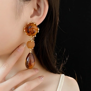 Vintage amber resin drop earrings with gold metal accents and three-tier dangle design