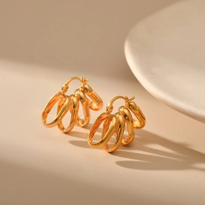 Detailed close-up of 18K gold plated multi-hoop earrings with textured oval rings