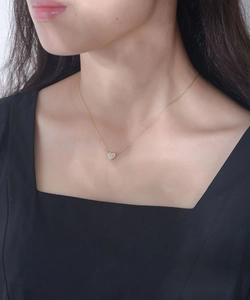 Close-up of a s925 silver heart necklace with zircon stones on a female model