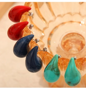Macro de boucles d'oreilles goutte en résine colorée avec détail de texture marbrée