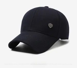 Detail of navy blue baseball cap featuring a vintage metal shield badge and stitched brim