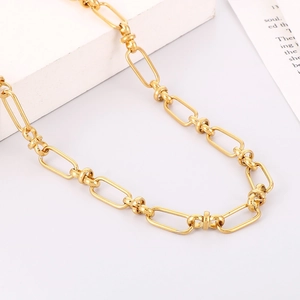 Macro detail of golden paperclip chain link necklace on minimalist aesthetic background