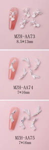 Detailed view of silver bow nail charms with heart pearls and sparkling rhinestones