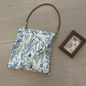 Detailed top view of floral tote bag with blue porcelain print and magnetic closure